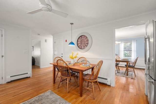 dining room featuring crown molding, baseboard heating, and light hardwood / wood-style flooring