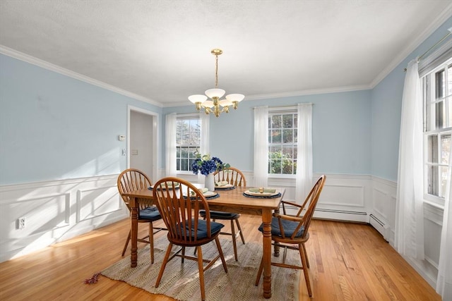 dining room featuring crown molding, a chandelier, and light hardwood / wood-style flooring