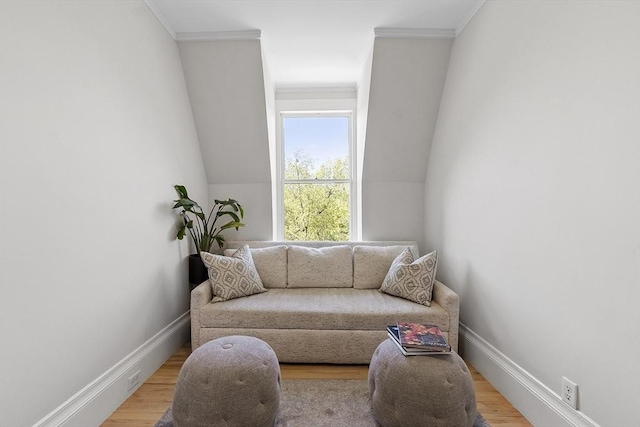 living area featuring baseboards, ornamental molding, and light wood finished floors
