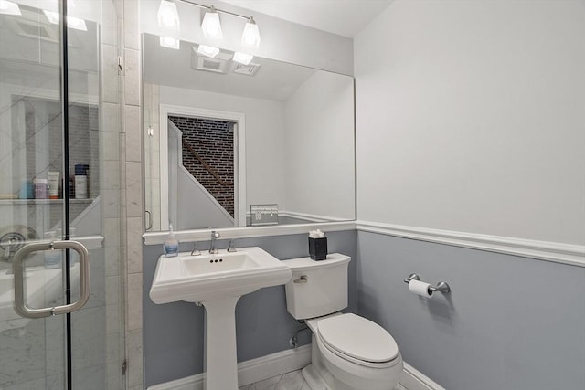 bathroom with baseboards, a shower stall, toilet, and marble finish floor