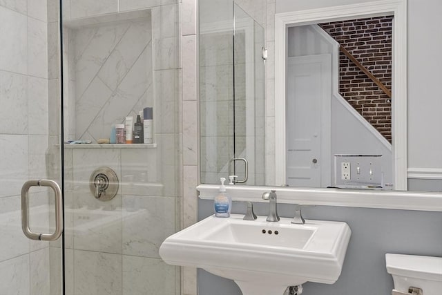 bathroom featuring a sink, a stall shower, and toilet