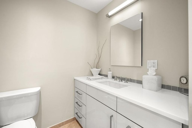 bathroom with toilet, tile patterned flooring, and vanity