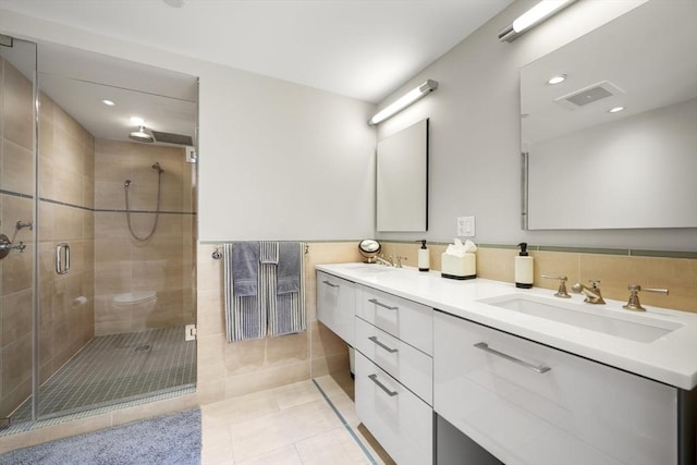 bathroom with tile patterned floors, walk in shower, and vanity