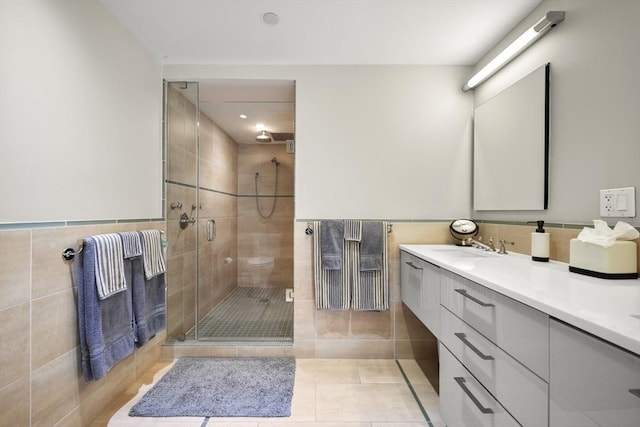 bathroom with tile walls, walk in shower, and vanity