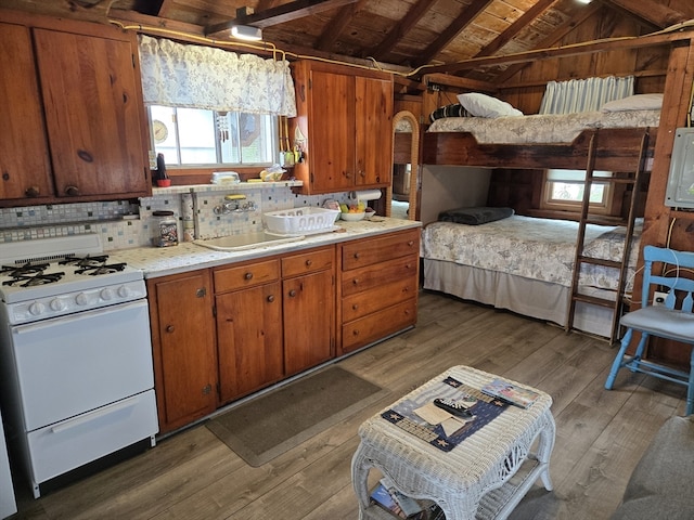 kitchen with lofted ceiling with beams, wooden ceiling, dark hardwood / wood-style flooring, white range with gas stovetop, and backsplash