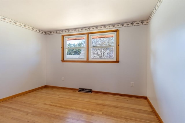 spare room featuring visible vents, baseboards, and light wood-style flooring