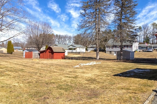 view of yard featuring an outdoor structure, a storage unit, and fence