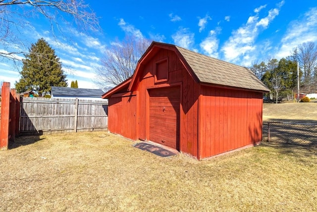 view of barn featuring a yard and fence