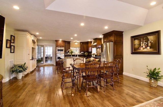 dining space featuring lofted ceiling, dark hardwood / wood-style flooring, and sink