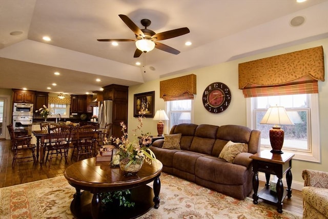 living room featuring ceiling fan, sink, and hardwood / wood-style flooring