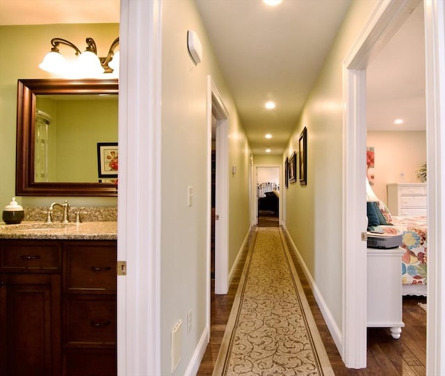 hall with dark hardwood / wood-style flooring and sink