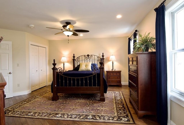 bedroom featuring ceiling fan, dark hardwood / wood-style flooring, a closet, and multiple windows