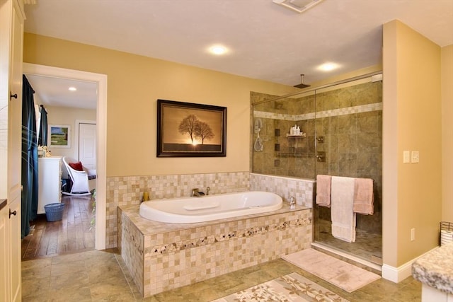 bathroom with independent shower and bath and tile patterned flooring