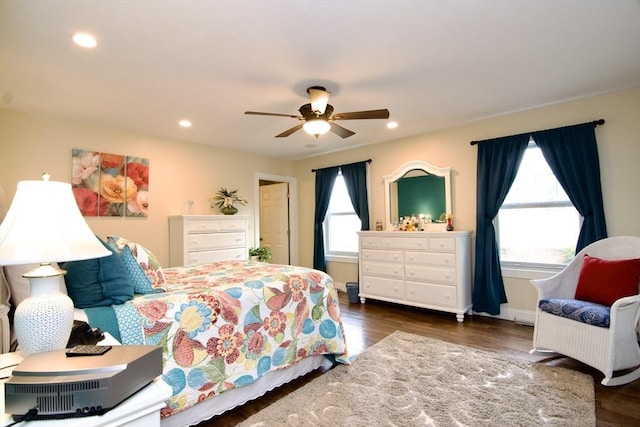 bedroom with ceiling fan, multiple windows, and dark hardwood / wood-style floors