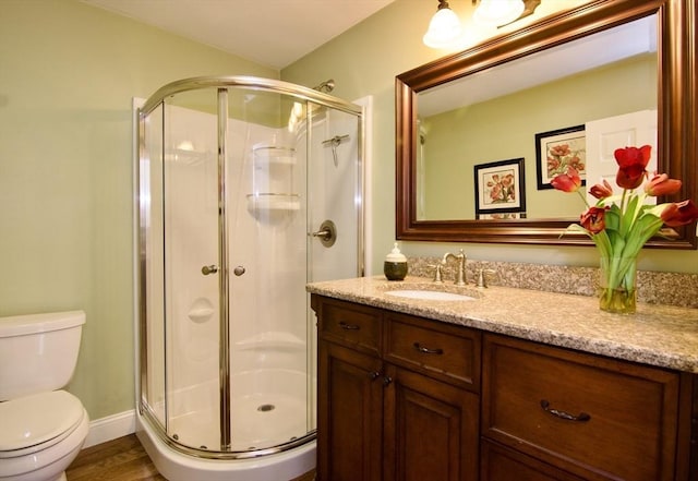 bathroom with vanity, toilet, hardwood / wood-style flooring, and walk in shower