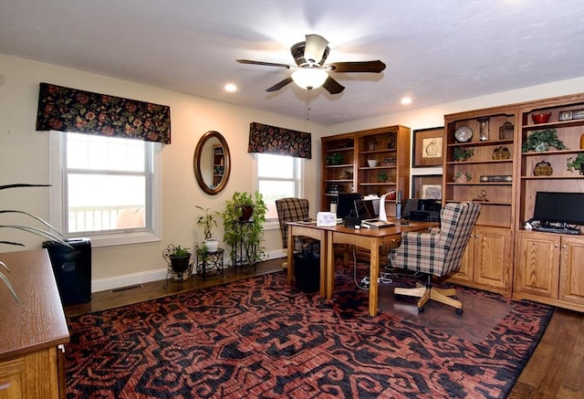 home office with dark wood-type flooring and ceiling fan