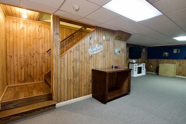 bar featuring carpet, a drop ceiling, and wood walls