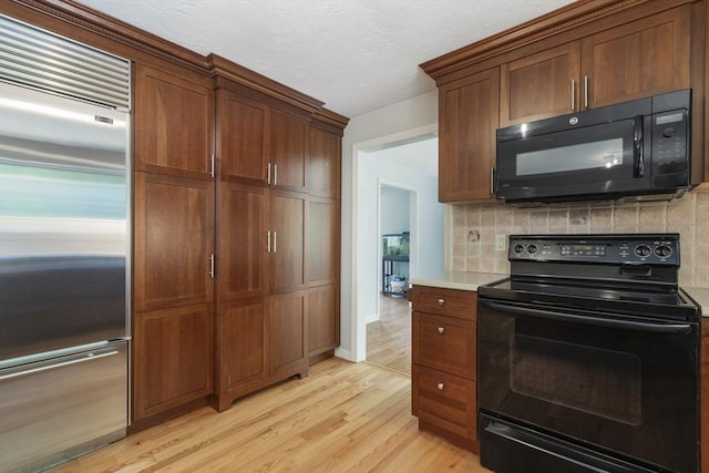 3 Howe St, Medway, MA 02053 - kitchen with black appliances, light wood-style flooring, backsplash, and light countertops