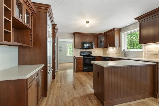 3 Howe St, Medway, MA 02053 - kitchen featuring black appliances, light wood-type flooring, tasteful backsplash, and plenty of natural light