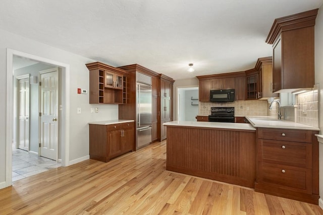 3 Howe St, Medway, MA 02053 - kitchen featuring black appliances, light wood-style floors, a sink, a peninsula, and tasteful backsplash