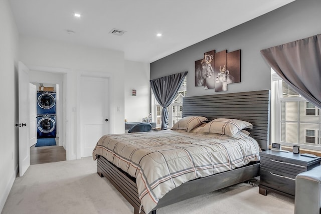 carpeted bedroom featuring stacked washer / drying machine and multiple windows