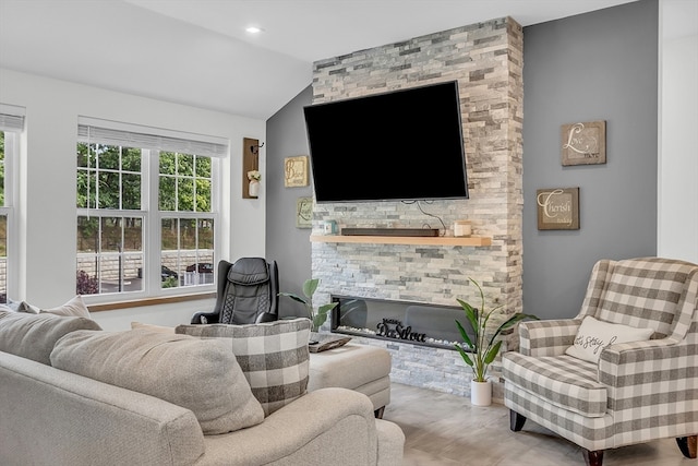 living room featuring hardwood / wood-style floors, a fireplace, and vaulted ceiling