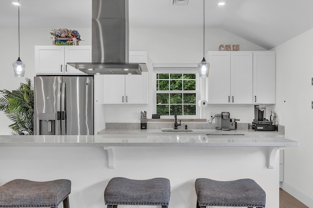 kitchen with vaulted ceiling, light stone countertops, stainless steel fridge with ice dispenser, island exhaust hood, and sink