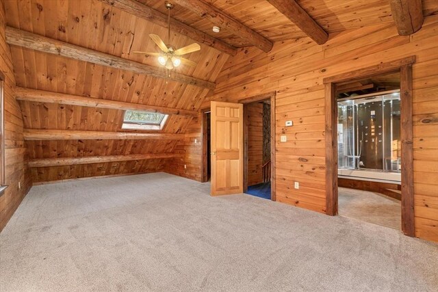 additional living space with ceiling fan, wooden ceiling, lofted ceiling with skylight, wood walls, and carpet