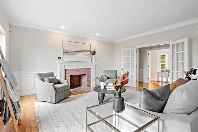 17 Arrowhead Ln, Westborough, MA 01581 - living area with french doors, crown molding, light wood-style flooring, wainscoting, and a fireplace