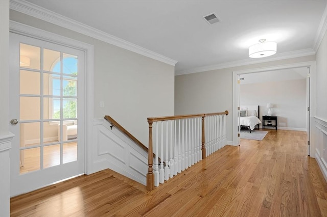 17 Arrowhead Ln, Westborough, MA 01581 - corridor with an upstairs landing, light wood-style floors, crown molding, a decorative wall, and wainscoting