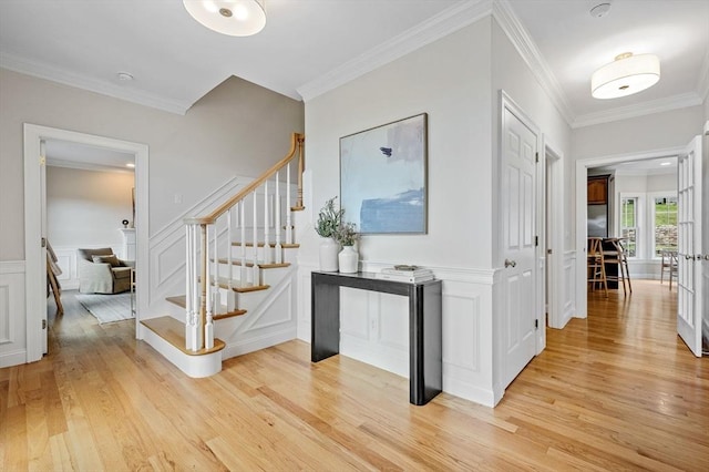 17 Arrowhead Ln, Westborough, MA 01581 - entrance foyer featuring light wood-style floors, stairway, crown molding, a decorative wall, and wainscoting