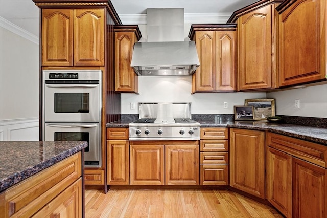 17 Arrowhead Ln, Westborough, MA 01581 - kitchen featuring wall chimney range hood, appliances with stainless steel finishes, ornamental molding, light wood-style flooring, and brown cabinets