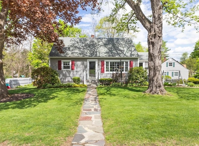 cape cod house featuring a front yard and a shingled roof