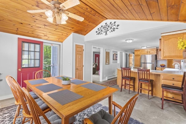 dining room with lofted ceiling, a baseboard heating unit, wooden ceiling, a ceiling fan, and baseboards