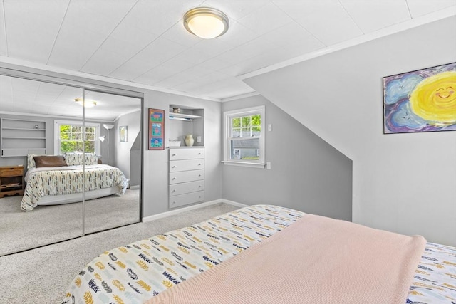 bedroom with a closet, carpet floors, baseboards, and crown molding