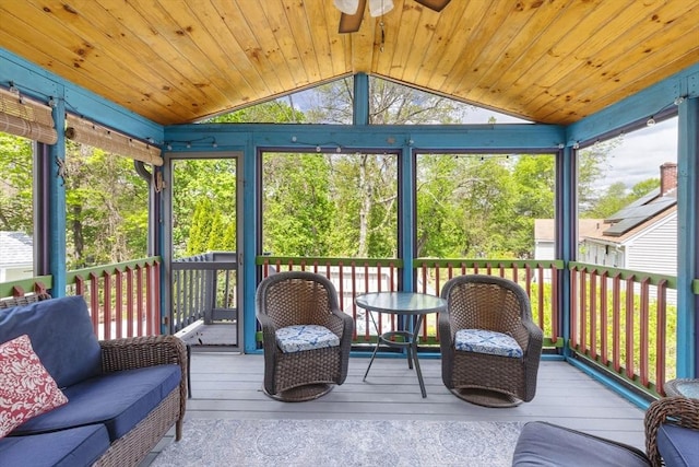sunroom featuring lofted ceiling, ceiling fan, and healthy amount of natural light