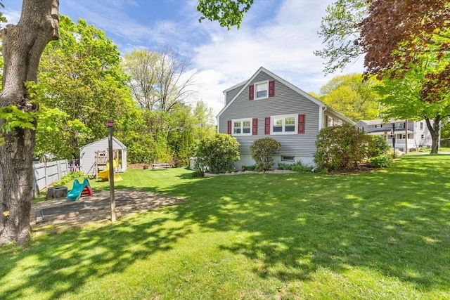 rear view of property featuring an outdoor structure and a shed