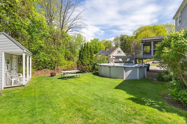 view of green lawn with a covered pool