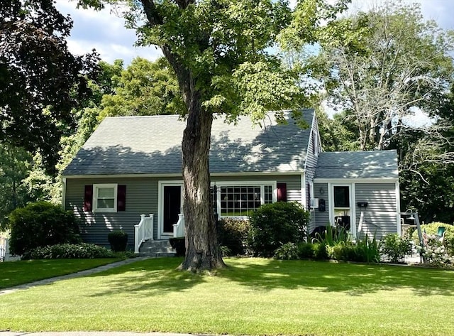 view of front facade featuring a front yard and roof with shingles