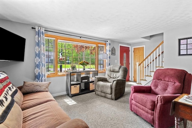 living area with carpet floors, stairway, baseboards, and a textured ceiling