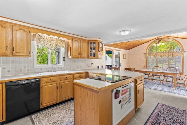 kitchen with black appliances, a sink, vaulted ceiling, plenty of natural light, and light countertops
