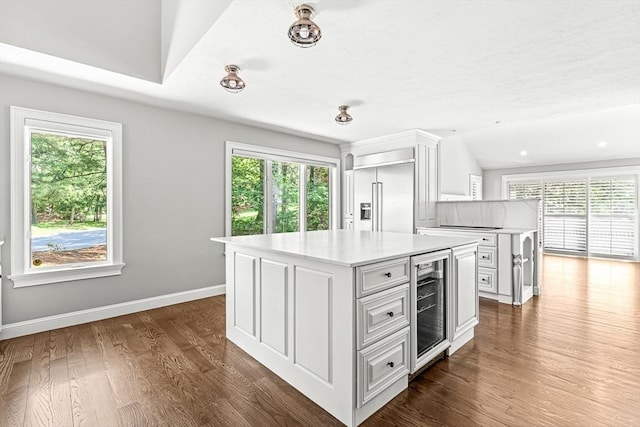 7 Wainwright Rd Unit 55, Winchester, MA 01890 - kitchen with beverage cooler, built in refrigerator, white cabinets, a kitchen island, and light countertops