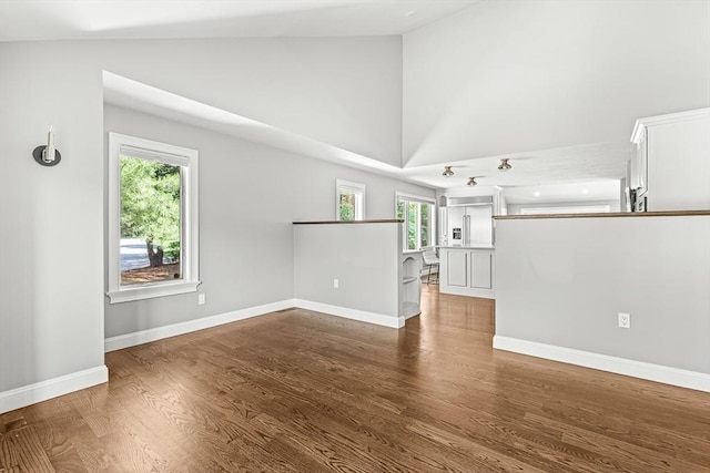 7 Wainwright Rd Unit 55, Winchester, MA 01890 - unfurnished living room featuring wood finished floors, baseboards, and high vaulted ceiling