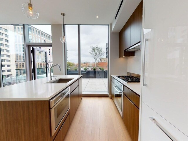 100 Shawmut Ave Unit 310, Boston, MA 02118 - kitchen with modern cabinets, stainless steel appliances, a sink, and light wood-style flooring