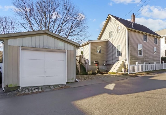 view of home's exterior with a garage and an outbuilding