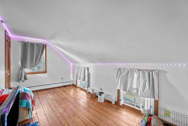 bonus room with wood-type flooring, vaulted ceiling, and a baseboard heating unit