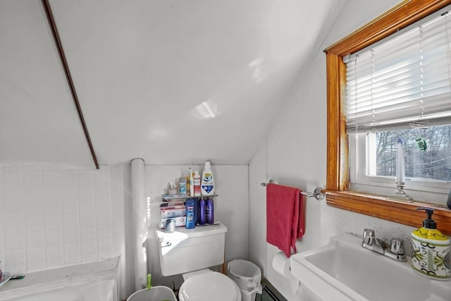 bathroom with sink, toilet, and lofted ceiling