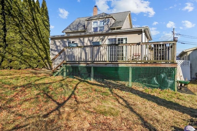 back of property featuring a lawn and a wooden deck