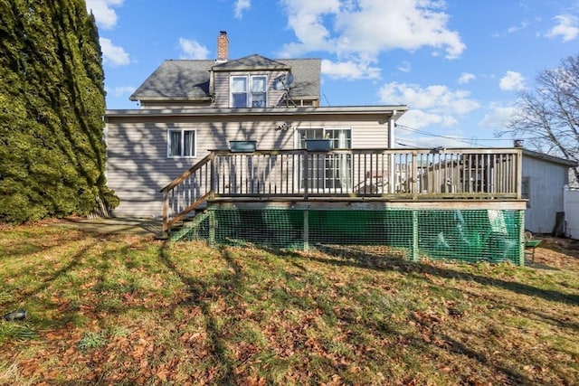 back of house featuring a wooden deck and a yard