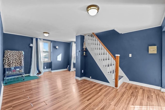 entrance foyer featuring a baseboard heating unit, crown molding, and hardwood / wood-style floors